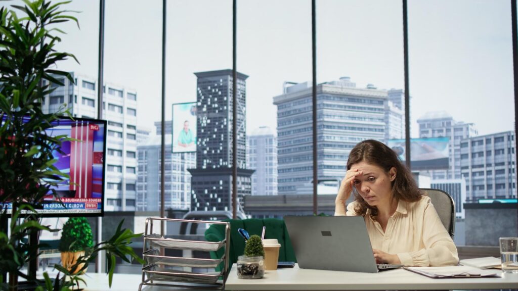Employee dealing with burnout and stress while working at a laptop - LeaveConsult