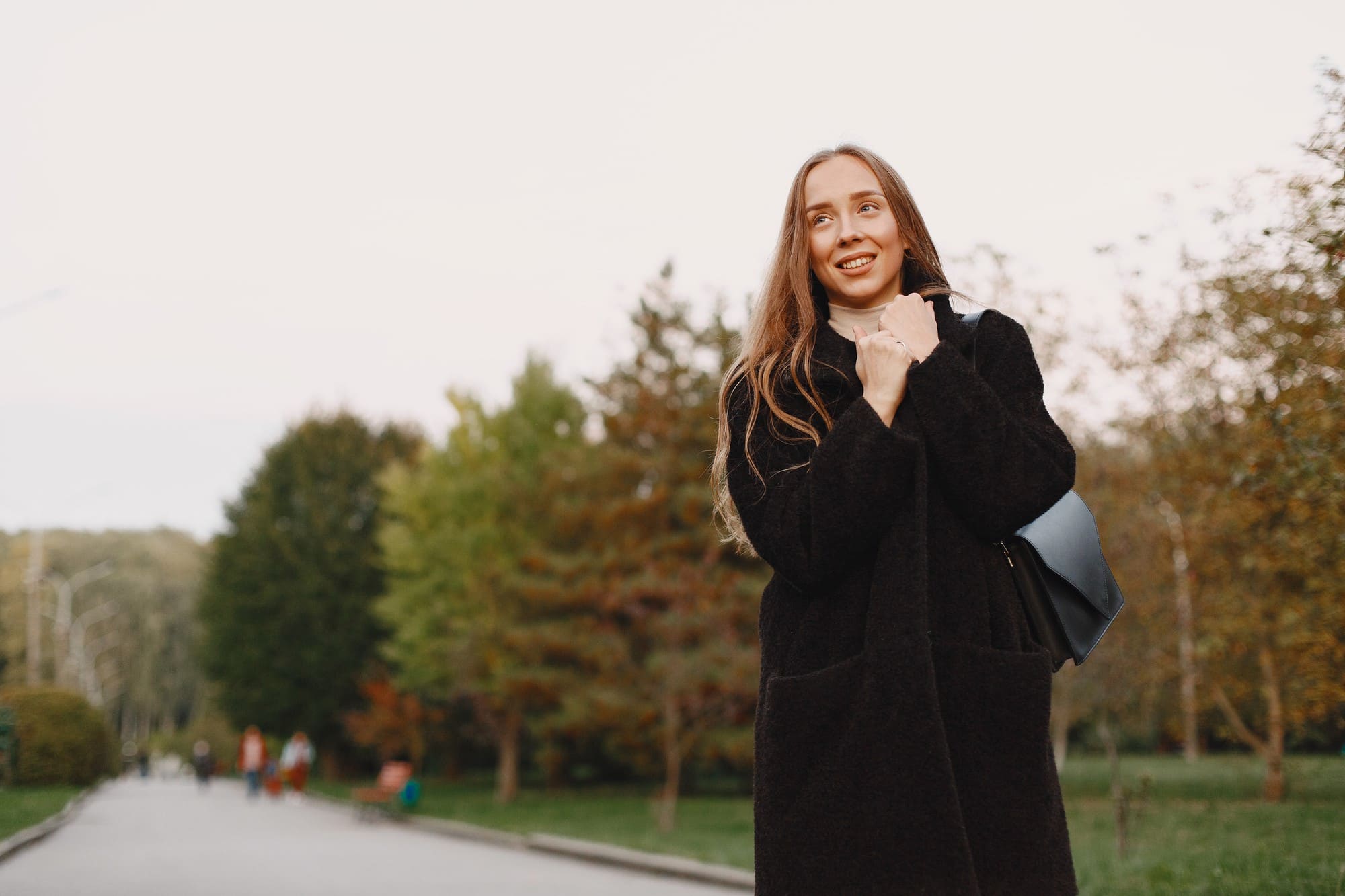Young woman enjoying a peaceful walk in a tree-lined park - LeaveConsult